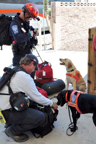 Rescue search dog handlers of the Federal Emergency Management Agency Nevada Urban Search and Rescue Task Force One prepare to store their personal equipment just before entering passenger screening July 20, 2011, at the 99th Logistics Readiness Squadron Deployment Center. FEMA and the Air Force jointly conducted an exercise to simulate recalling the Nevada Task Force for a disaster or emergency and preparing FEMA personnel and equipment to fly aboard a military aircraft. (U.S. Air Force photo by 2nd Lt. Ken Lustig/Released)