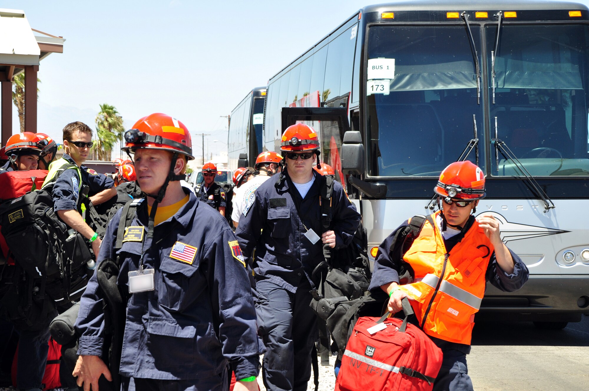 Members of the Federal Emergency Management Agency Nevada Urban Search and Rescue Task Force One disembark from their buses and gather their equipment just before entering passenger screening July 20, 2011, at the 99th Logistics Readiness Squadron Deployment Center. FEMA and the Air Force jointly conducted an exercise to simulate recalling the Nevada Task Force for a disaster or emergency and preparing FEMA personnel and equipment to fly aboard a military aircraft. (U.S. Air Force photo by 2nd Lt. Ken Lustig/Released)