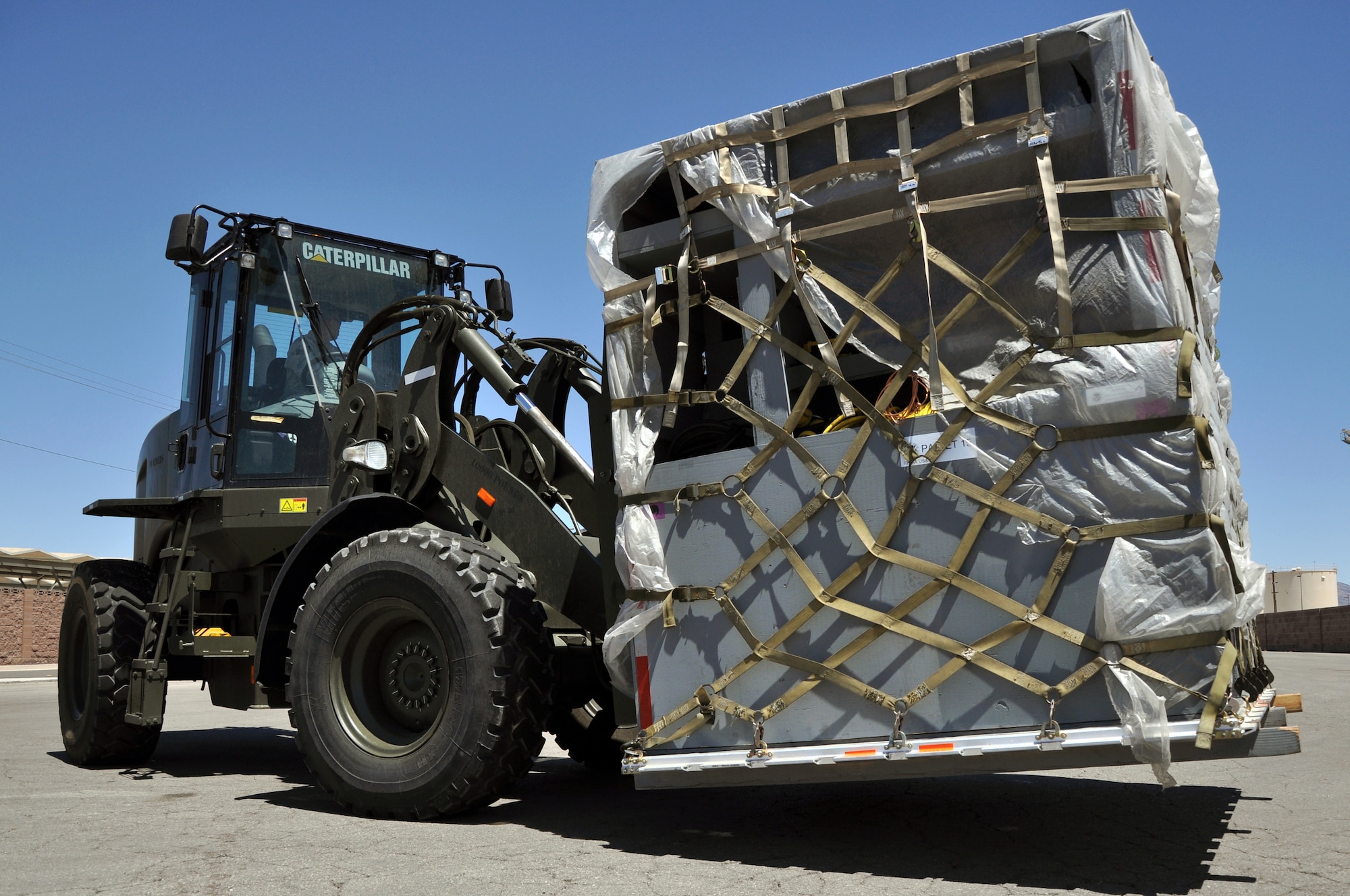 Tech. Sgt. Jeffrey Maquindang, 99th Logistics Readiness Squadron NCO in charge of deployment training, maneuvers one of the Federal Emergency Management Agency Nevada Urban Search and Rescue Task Force One's equipment pallets July 20, 2011, in the cargo marshalling yard at Nellis Air Force Base, Nev. FEMA and the Air Force jointly conducted an exercise to simulate recalling the Nevada Task Force for a disaster or emergency and preparing FEMA personnel and equipment to fly aboard a military aircraft. (U.S. Air Force photo by 2nd Lt. Ken Lustig/Released)