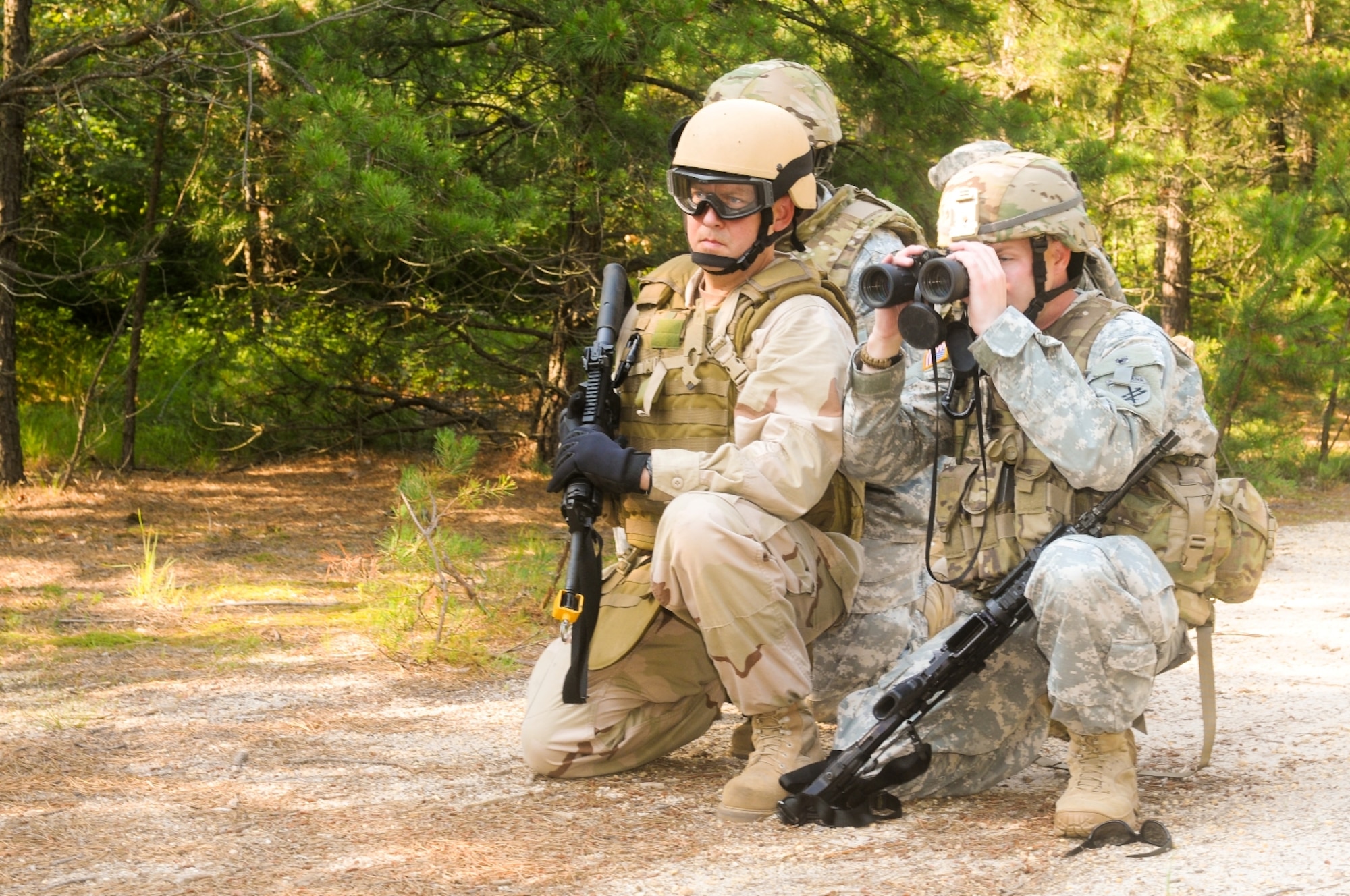Petty Officer 1st Class Rick Blankenship, Navy Cargo Handling Battalion 4, and a Soldier serving as spotter, identify a mock improvised explosive device during a joint service training foot patrol June 28 on Joint Base McGuire-Dix-Lakehurst. Blankenship said the training was good for familiarizing Sailors with challenges they may face while deployed to a combat zone on land. (U.S. Army photo by Spc. Darryl L. Montgomery/Released)