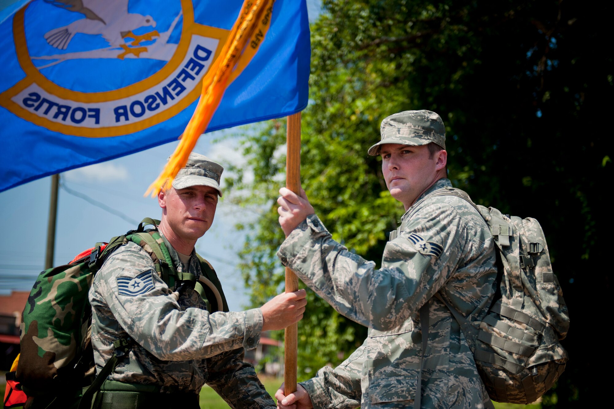 U.S. Air Force Tech. Sgt. Kurt Pinkowski, 23rd Security Forces Squadron investigations NCO in charge from Moody Air Force Base, Ga., left, passes the Ruck March to Remember guidon to Senior Airman Josh McCarty, 78th Security Forces Squadron desk sergeant from Robins Air Force Base, Ga., Aug. 9, 2011, in Plains, Ga. The passing of the guidon officially granted Robins AFB as the lead unit of the march for the next leg. (U.S. Air Force photo by Staff Sgt. Jamal D. Sutter/Released)