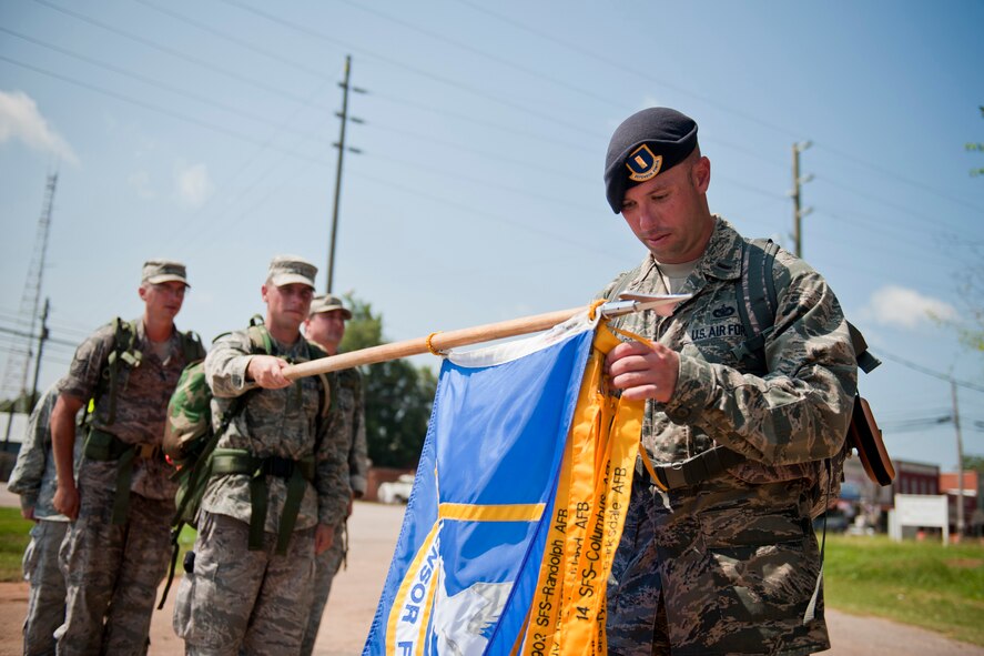 U.S. Air Force 2nd Lt. Spencer Duclos, 23rd Security Forces Squadron logistics officer, attaches his unit’s ribbon to the Ruck March to Remember guidon Aug. 9, 2011, in Plains, Ga. Each participating base attaches their unit’s ribbon to the guidon before passing it to the next group. (U.S. Air Force photo by Staff Sgt. Jamal D. Sutter/Released)