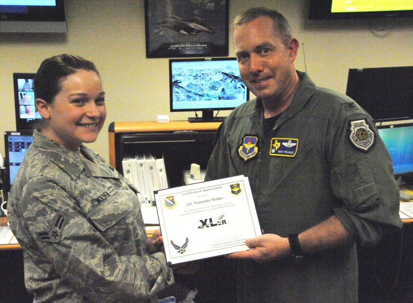 LAUGHLIN AIR FORCE BASE, Texas – Airman 1st Class Samantha Molder, 47th Flying Training Wing command post, poses with Col. Michael Frankel, 47th FTW commander, after being presented the XLer of the Week award here Aug. 3. The XLer is a weekly award chosen by wing leadership and given to those who consistently make outstanding contributions to Laughlin and their unit. (U.S. Air Force photo by Airman 1st Class Blake Mize)