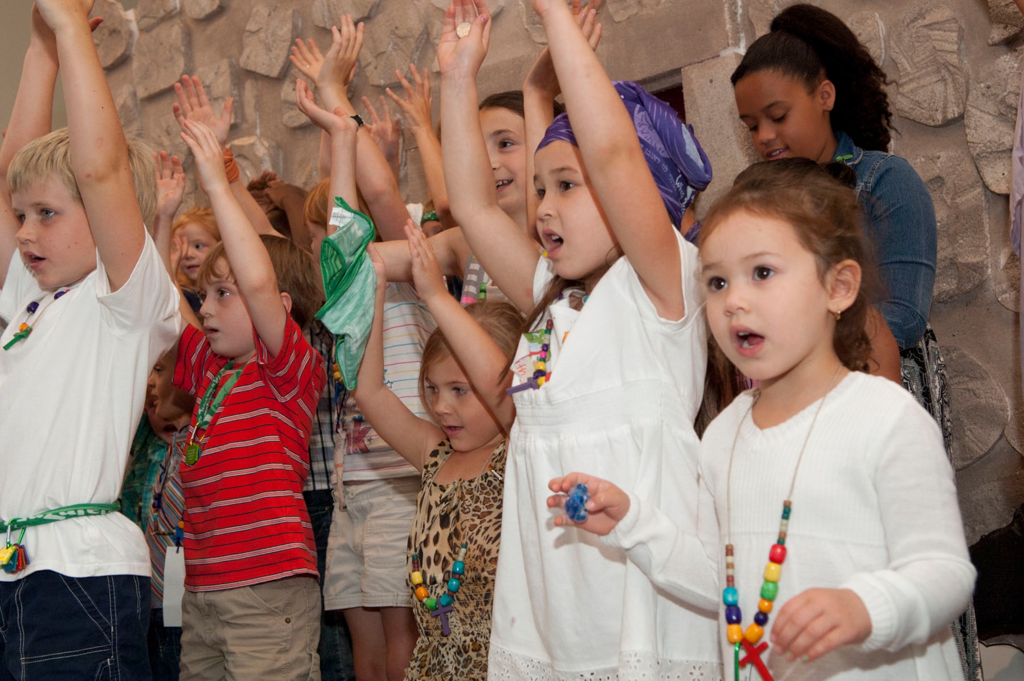 HANSCOM AIR FORCE BASE, Mass. – Children raise their hands as they sing a song during Vacation Bible School at the base chapel Aug. 5. The children learned lessons, made crafts and more during the week-long event. (U.S. Air Force photo by Mark Wyatt)