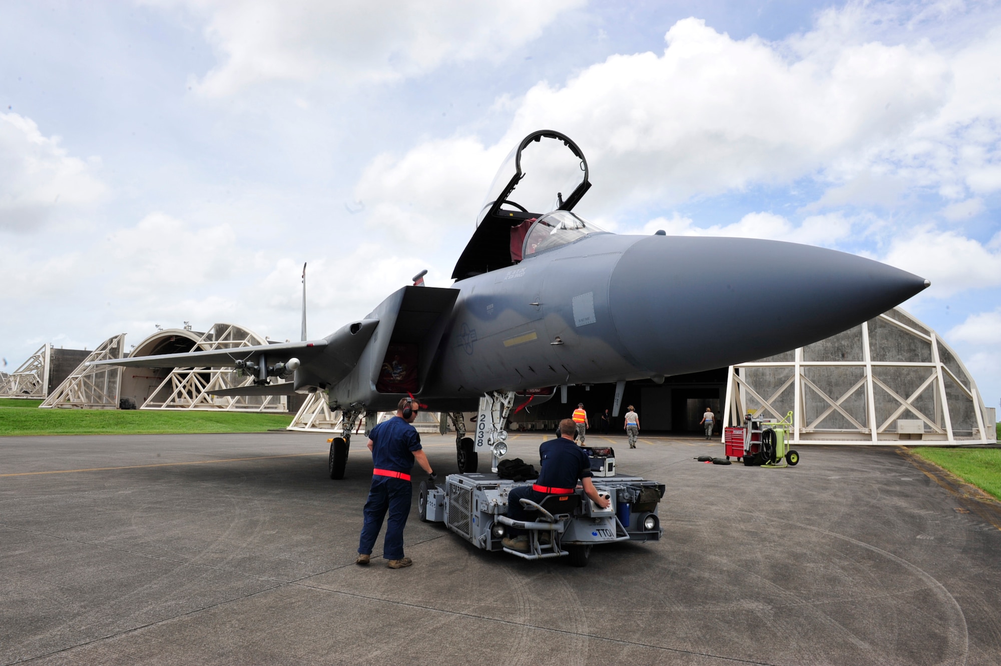 Members of the 18th Maintenance Group attach an aircraft handler to an F-15 Eagle to place it in a hardened aircraft shelter in preperation for Typhoon Muifa at Kadena Air Base, Japan, Aug. 3. Okinawa's typhoon season lasts from June through November. (U.S. Air Force photo/Staff Sgt. Lakisha A. Croley)