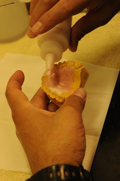 Edward Ibarra, 1st Special Operations Dental Squadron, applies liquid acrylic for a temporary removable partial denture at the dental lab, Hurlburt Field, Fla., Aug. 3, 2011. The liquid acrylic dries pink so model has the appearance of a normal human mouth.(U.S. Air Force photo by Senior Airman Eboni Reams)
