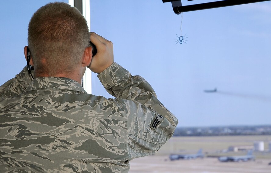 Senior Airman Anthony Murphy, 2nd Operations Squadron air traffic controller, watches through binoculars as an aircraft takes off from the runway on Barksdale Air Force Base, La., Aug. 9. The tower averages more than 30 operations over a 24-hour period and is manned seven days a week. (U.S. Air Force photo/Senior Airman Amber Ashcraft) (RELEASED)