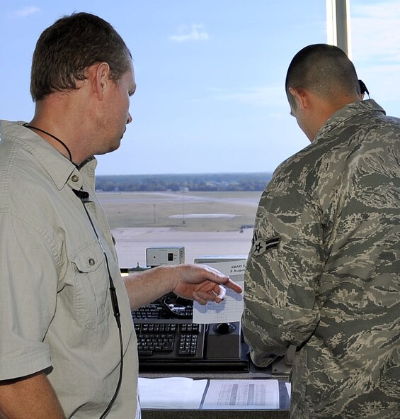 Mark Whipple and Airman 1st Class Carlos Villegas, both of the 2nd Operations Squadron, discuss aircraft arrivals on Barksdale Air Force Base, La., Aug. 9. The tower has at least four air traffic controllers  on shift at all times, including the local controller, flight data, ground controller and the watch supervisor. More than 30 operations are run per day and the tower is manned 24/7. (U.S. Air Force photo/Senior Airman Amber Ashcraft) (RELEASED)