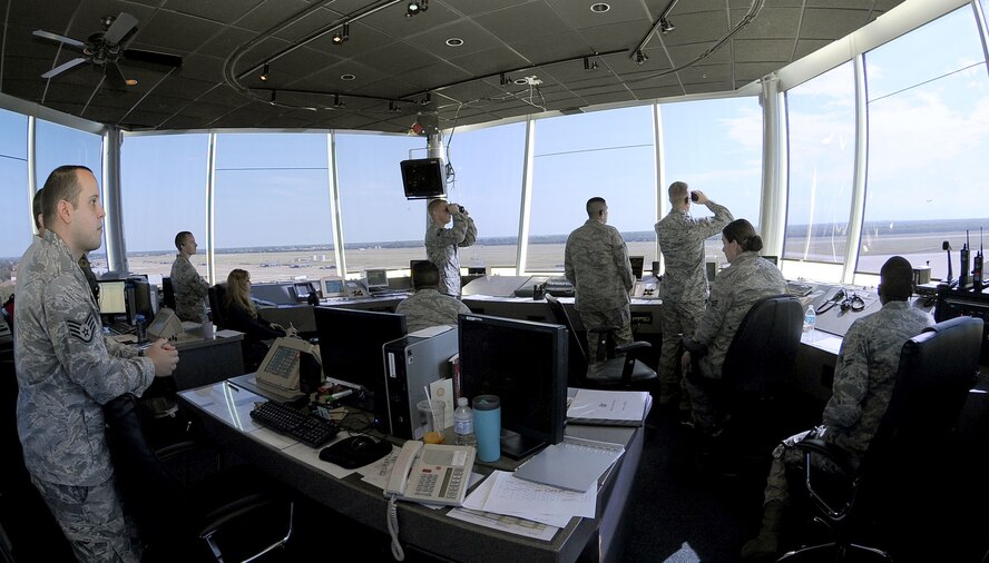 Several Airmen of the 2nd Operations Squadron air traffic control tower, watch as two aircraft enter the runway for takeoff on Barksdale Air Force Base, La., Aug. 9, 2011. The tower has at least four air traffic controllers on shift at all times, including the local controller, flight data, ground controller and the watch supervisor. More than 30 operations are run per day and the tower is manned 24/7. (U.S. Air Force photo/Senior Airman Amber Ashcraft)(RELEASED) 