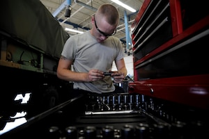 Airman 1st Class Matthew Fincher chooses the appropriate size socket Aug. 9 at the vehicle maintenance shop at Joint Base Charleston - Air Base  Fincher is in training at the shop and is learning to remove the bolts from a wheel hub.  Fincher is from the 628th Logistics Readiness Squadron. (U.S. Air Force photo/ Staff Sgt. Nicole Mickle)  