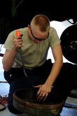 Airman1st Class Matthew Fincher uses a crow bar on a wheel hub Aug. 9 at the vehicle maintenance shop at Joint Base Charleston - Air Base. Fincher is from the 628th Logistics Readiness Squadron.  (U.S. Air Force photo/ Staff Sgt. Nicole Mickle)