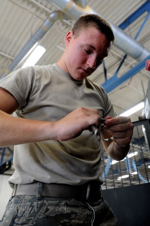 Airman 1st Class Andrew Keller checks the size of a socket as he prepares to repair a leaking radiator hose at Joint Base Charleston - Air Base Aug. 9. Airman Keller is from the 628th Logistics Readiness Squadron.  (U.S. Air Force photo/ Staff Sgt. Nicole Mickle) 