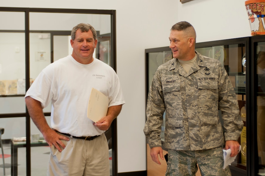 Valdosta State University football coach David Dean, left, and U.S. Air Force Col. Randall Richert, 820th Base Defense Group commander, talk about the collection of championship trophies displayed in the VSU Athletic Field House in Valdosta, Ga., Aug. 7, 2011. Richert was invited to the players’ first team meeting to stress the importance of teamwork and to motivate them before their season begins Sept. 3, 2011. (U.S. Air Force photo by Andrea Thacker/Released)