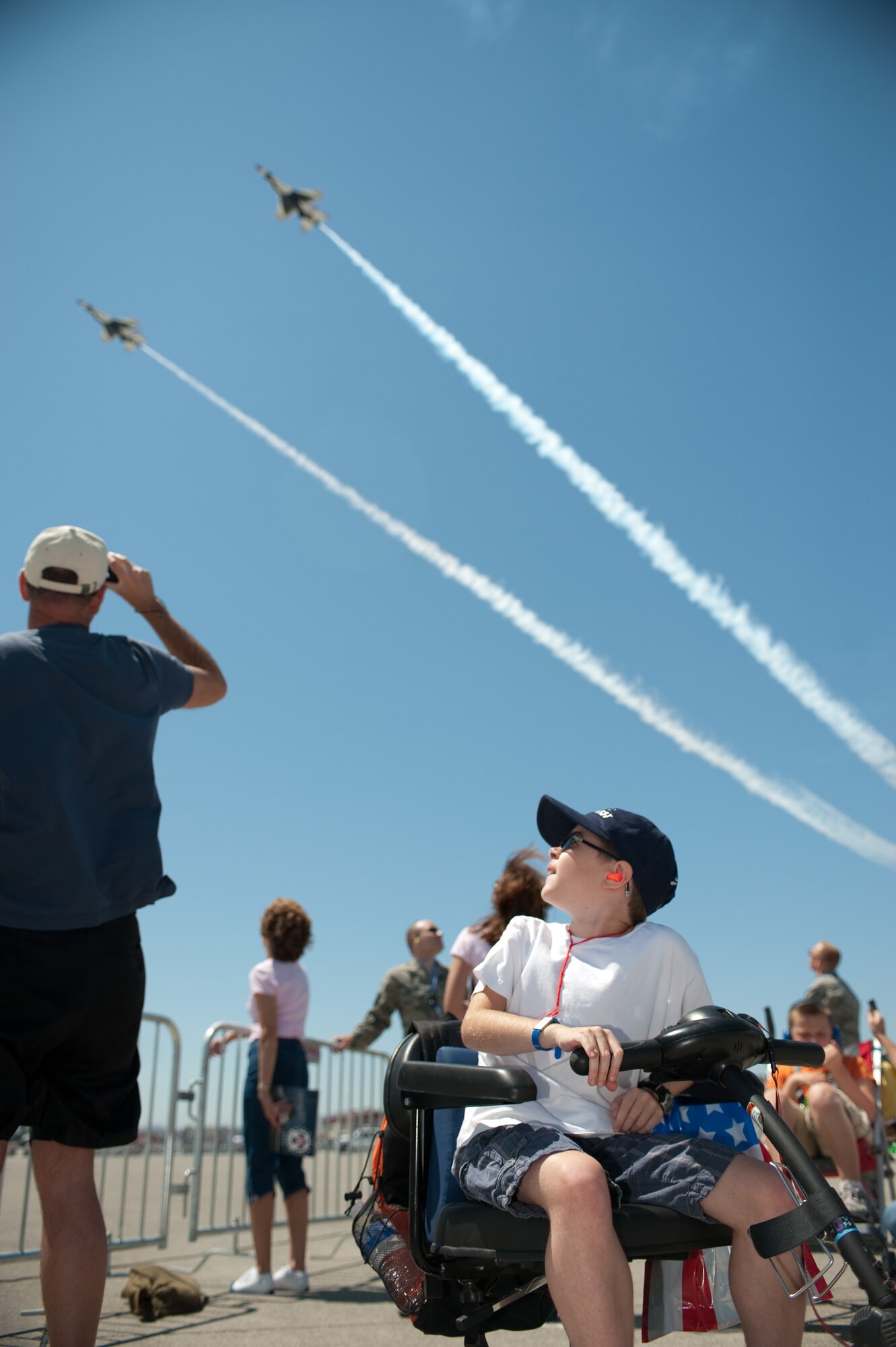 Alex Mddux,11, and his father, enjoy a Thunderbirds performance July 29 as part of the Make-A-Wish Foundation event. The Special Needs Task Force supported the event with supplies and volunteers. U.S. Air Force photo/Ken Wright