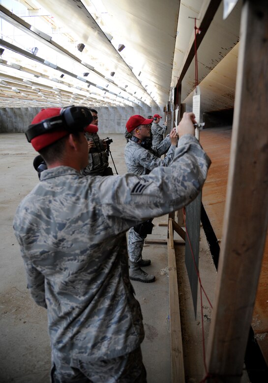 WHITEMAN AIR FORCE BASE, Mo. - Senior Airmen William Peterson and Richard Hovland, 509th Security Forces Squadron combat arms and maintenance instructors, check shooters' training targets prior to a M4 Carbine qualification fire here, July 28, 2011. The CATM instructors are trained to read the targets and inform the shooters if they need to adjust their sights, improve on their breathing or work on other firing fundamentals. (U.S. Air Force photo by Airman 1st Class Cody H. Ramirez)
