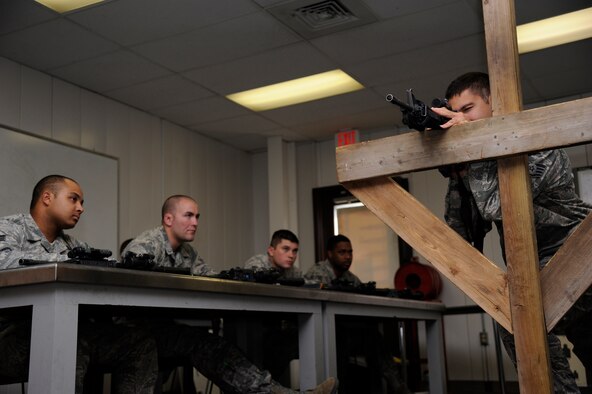 WHITEMAN AIR FORCE BASE, Mo. - Staff Sgt. Roger Scott, 509th Security Forces Squadron combat arms and maintenance instructor, teaches 509th SFS members how to stand while shooting July 28, 2011 for their upcoming M4 Carbine firing qualification. Security force members are required to requalify every six months and must conduct a day and night fire.   (U.S. Air Force photo by Airman 1st Class Cody H. Ramirez)