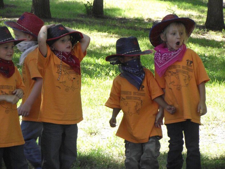 From left to right: Aaron Wilmoth, 5, Jordan Willets, 5, Isaiah Gaines, 5, and Hayley Hatfield, 5, dressed as cowboys and cowgirls react to a barrel racing demonstration.  (Courtesy Photo)