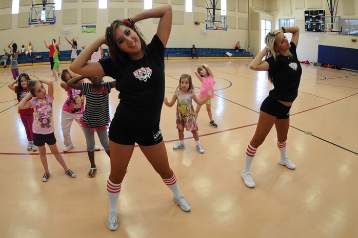 Kailli Mitchm and Lama Carey, Las Vegas Locomotion dancers, teach dance moves to young girls at the Nellis Youth Center Aug. 5, 2011, at Nellis Air Force Base, Nev.  The Las Vegas Locos football players, dancers and coaches toured Nellis AFB and spent time at the Nellis Youth Center teaching the children the fundamentals of football, dancing and sportsmanship. (U.S. Air Force photo by Staff Sgt. Taylor Worley/ Released)