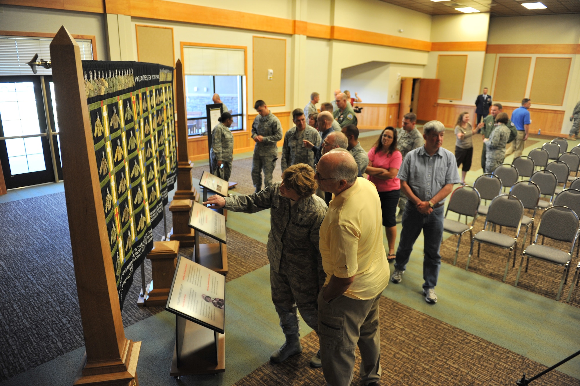 Malmstrom Airmen and families look at the Lost Heroes Art Quilt at the ceremony held July 28 at the Grizzly Bend.  The quilt was created to honor the memory of the American men and women who have lost their lives in Iraq and Afghanistan since Sept. 11, 2001.  (U.S. Air Force photo/John Turner)