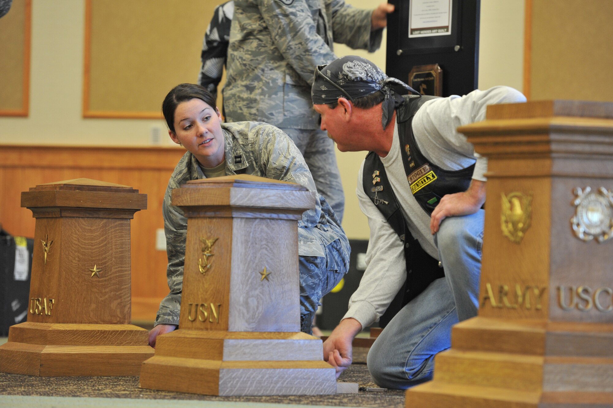 Capt. Moira Tracy, section commander with the 819th RED HORSE Squadron, and Rick English, a member of the Patriot Guard, set up podiums for all branches of the military.  (U.S. Air Force photo/John Turner)