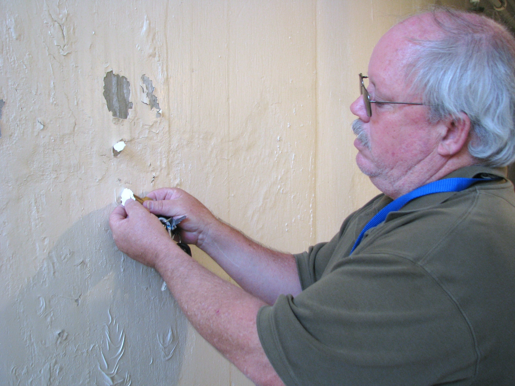 Gary Peddecord, systems automation and senior calibration specialist, shows how badly the paint is peeling throughout the underground thrust test facility at Pad 18. The facility was first painted in the mid-1950s with lead-based paint, which will be removed as the structure is renovated. (Air Force photo by Diane Betzler)