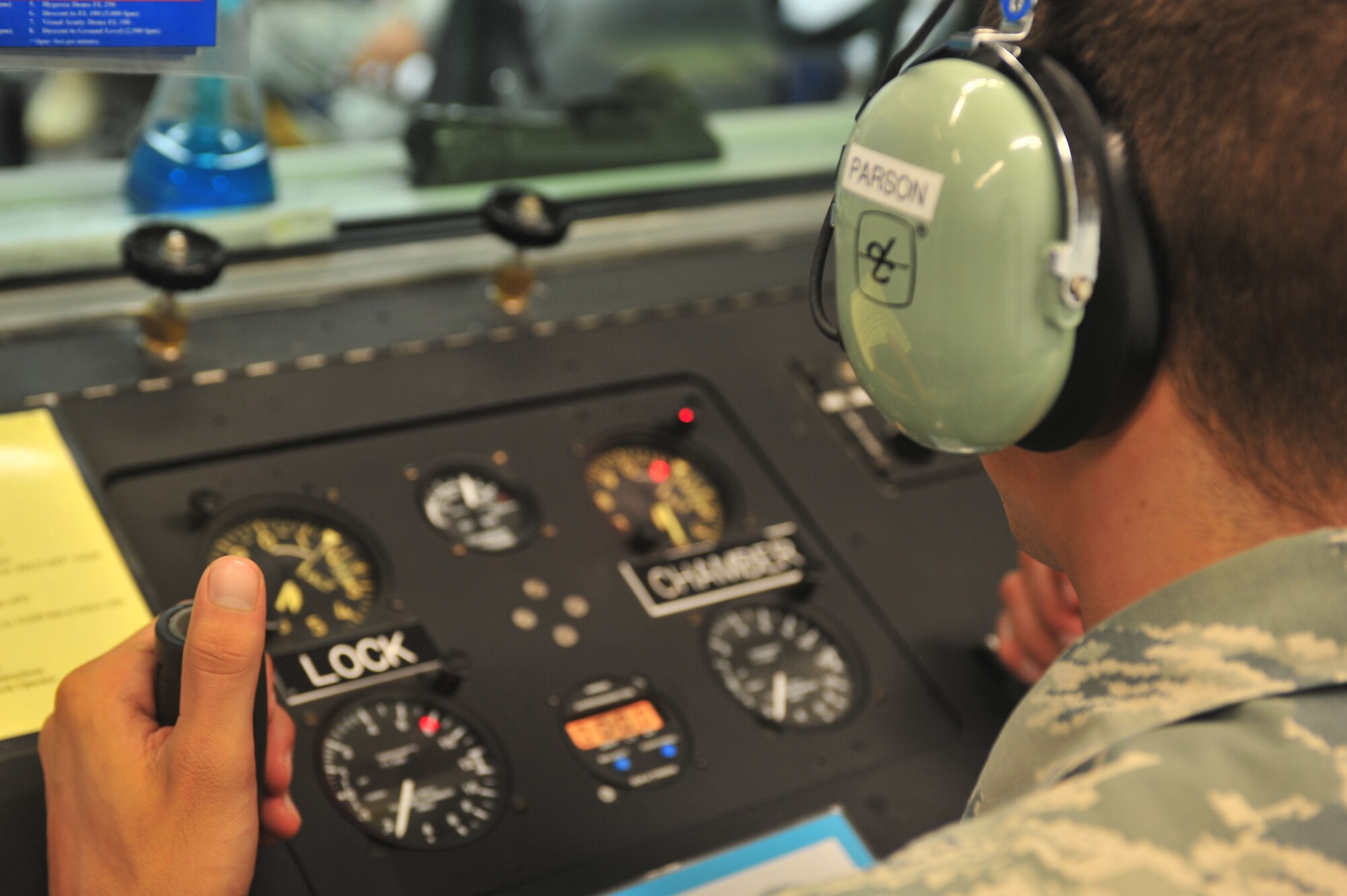 U.S. Air Force Airman 1st Class Justin Parson, 20th Aerospace Medicine Squadron physiology technician, helps control the pressure of the chamber for an efficient training exercise, Shaw Air Force Base, S.C. Aug. 10, 2011. High altitude training is a necessity before flying and must be completed to be on flying status. (U.S. Air Force photo by Airman 1st Class Ashley Gardner)(Released)