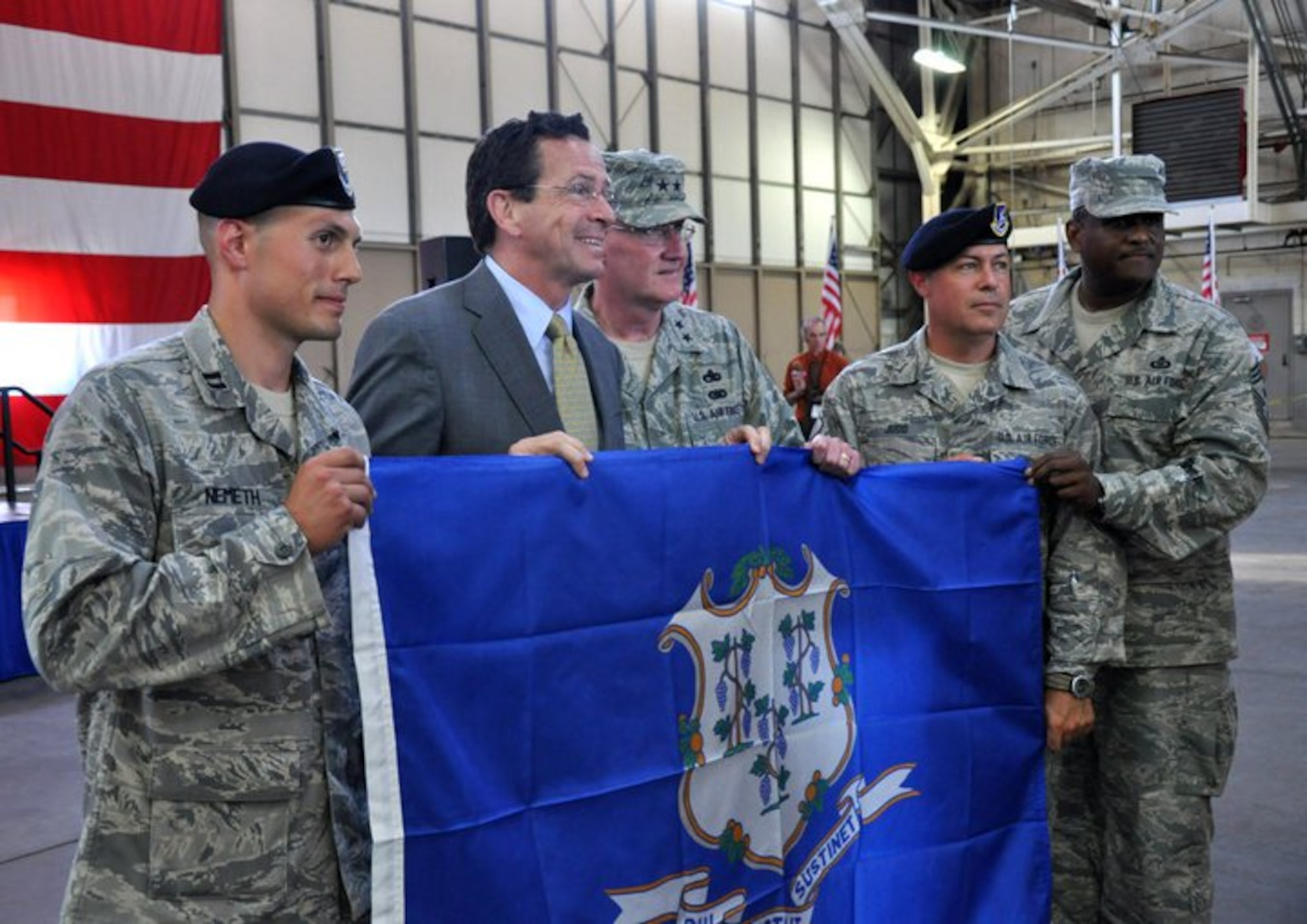 Gov. Dannel P. Malloy poses with Capt. Andrew Nemeth, Maj. Gen. Thaddeus Martin, Master Sgt. Daniel Judd and State Command Chief Master Sgt. John Carter in the main hangar at Bradley Air National Guard Base, East Granby, Conn. July 6, 2011. The Connecticut state flag was presented to Capt. Nemeth, who will command the deployed security forces troops, following a formal Send Off Ceremony held in honor of members of the 103rd Security Forces and 103rd Civil Engineer Squadrons who have since deployed to Afghanistan. (U.S. Air Force photo by Army 2nd Lt. Emily Hein)
