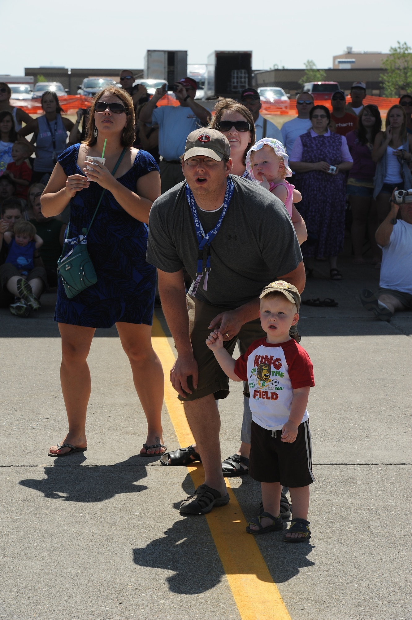 Colton Cron, 3, holds on to the finger of his dad, Keith Cron, during an aerial performance by one of the many aircraft performing at the air show July 31.  His mother; Christina Cron, younger sister; Ella Cron, 1; and another spectator, Lisa Lord, watch from behind.  (U.S. Air Force photo/Beau Wade) 