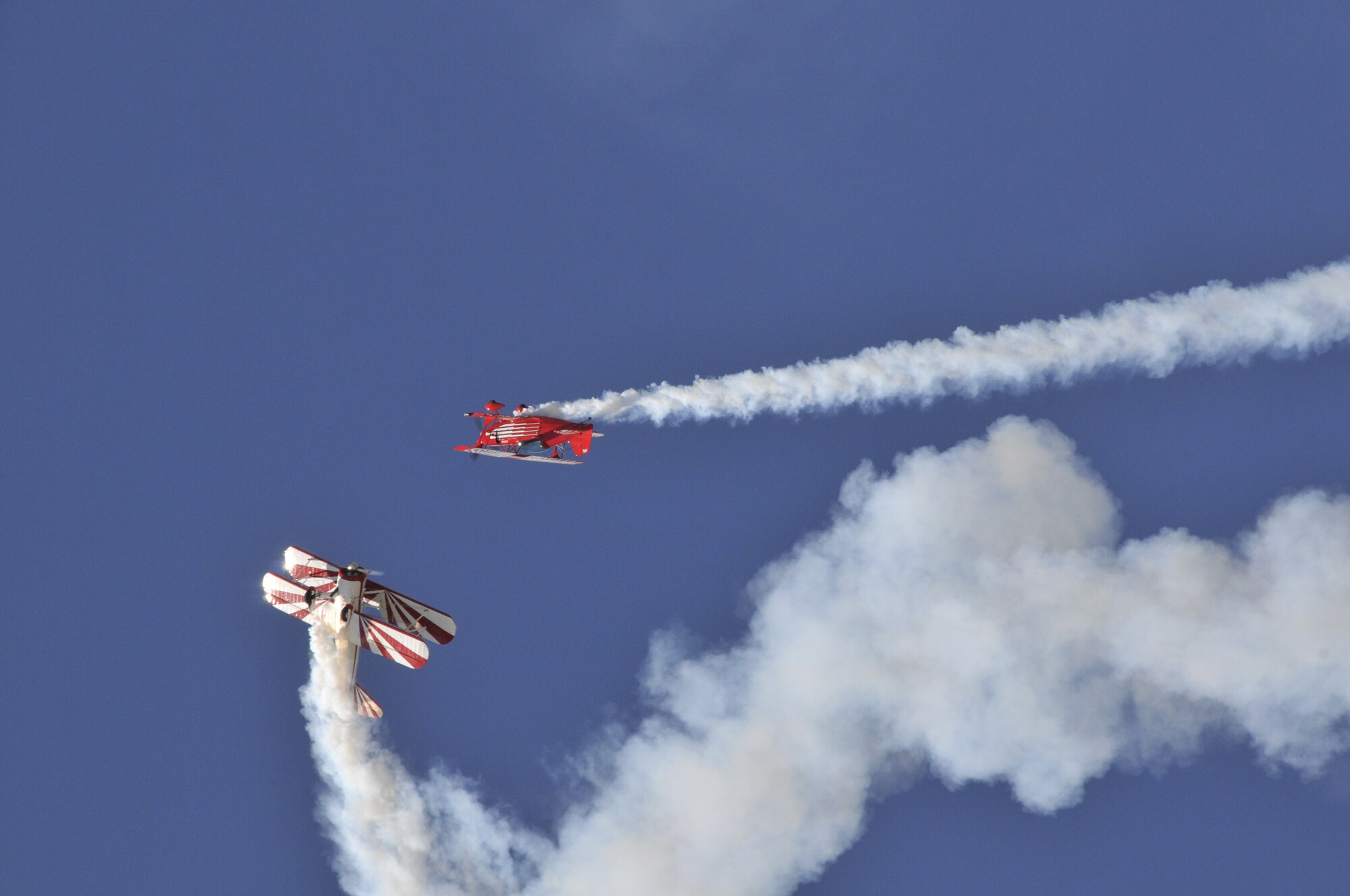 The red Christian Eagle II, flown by Buck Roetman, accompanied Gary Rower flying the white and red Stearman during the unlike aircraft performance in the air show.  (U.S. Air Force photo/John Turner)