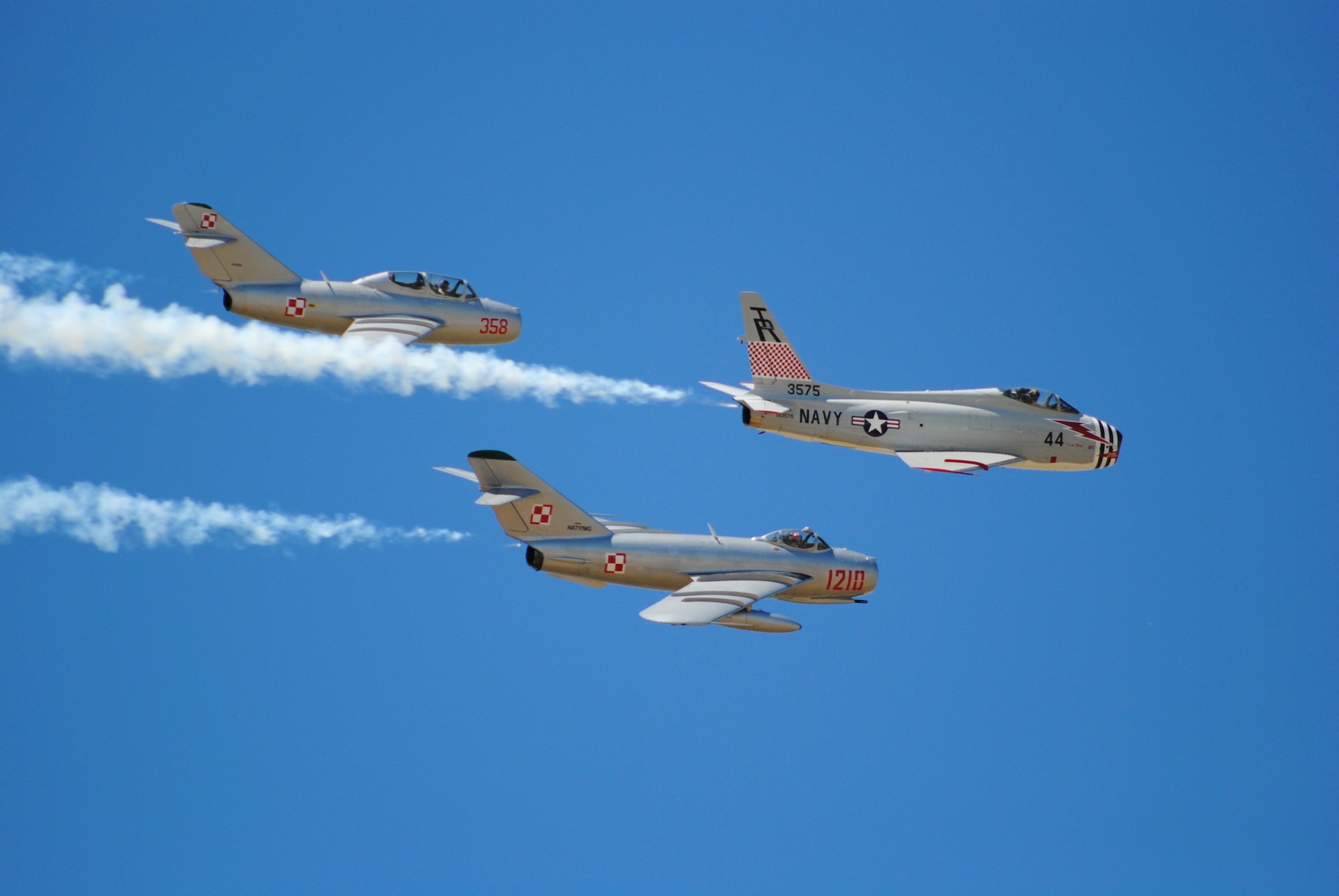 The MiG 15, MiG 17 and FJ-4 Fury Fighters, perform the world's only 3-jet warbird Dog Fight during Montana's Military Open House.  The FJ-4 Fury pictured was built in 1958 and is the last one flying in the world.  (U.S. Air Force photo/Airman Cortney Paxton)