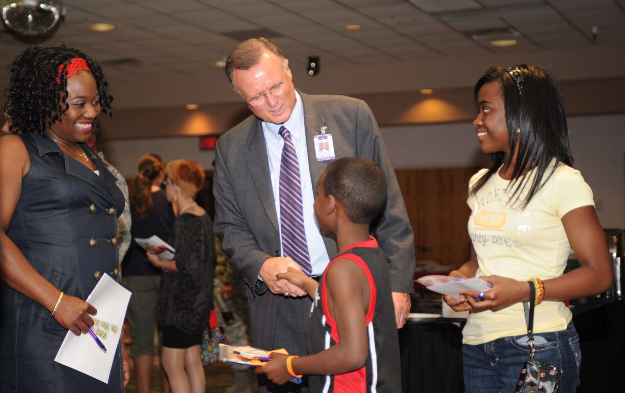 Tanya Thompson, military spouse, and her children meet with Terry Myers, Clovis Municipal Schools superintendant, at the First Friday ?Back to School Bash?, Aug.5, 2011. The Airman and Family Readiness Center co-hosted the event held at the Landing Zone at Cannon Air Force Base, N.M., to allow Cannon families to meet local school officials. (U.S. Air Force photo by Airman 1st Class Alexxis Pons Abascal)(RELEASED)