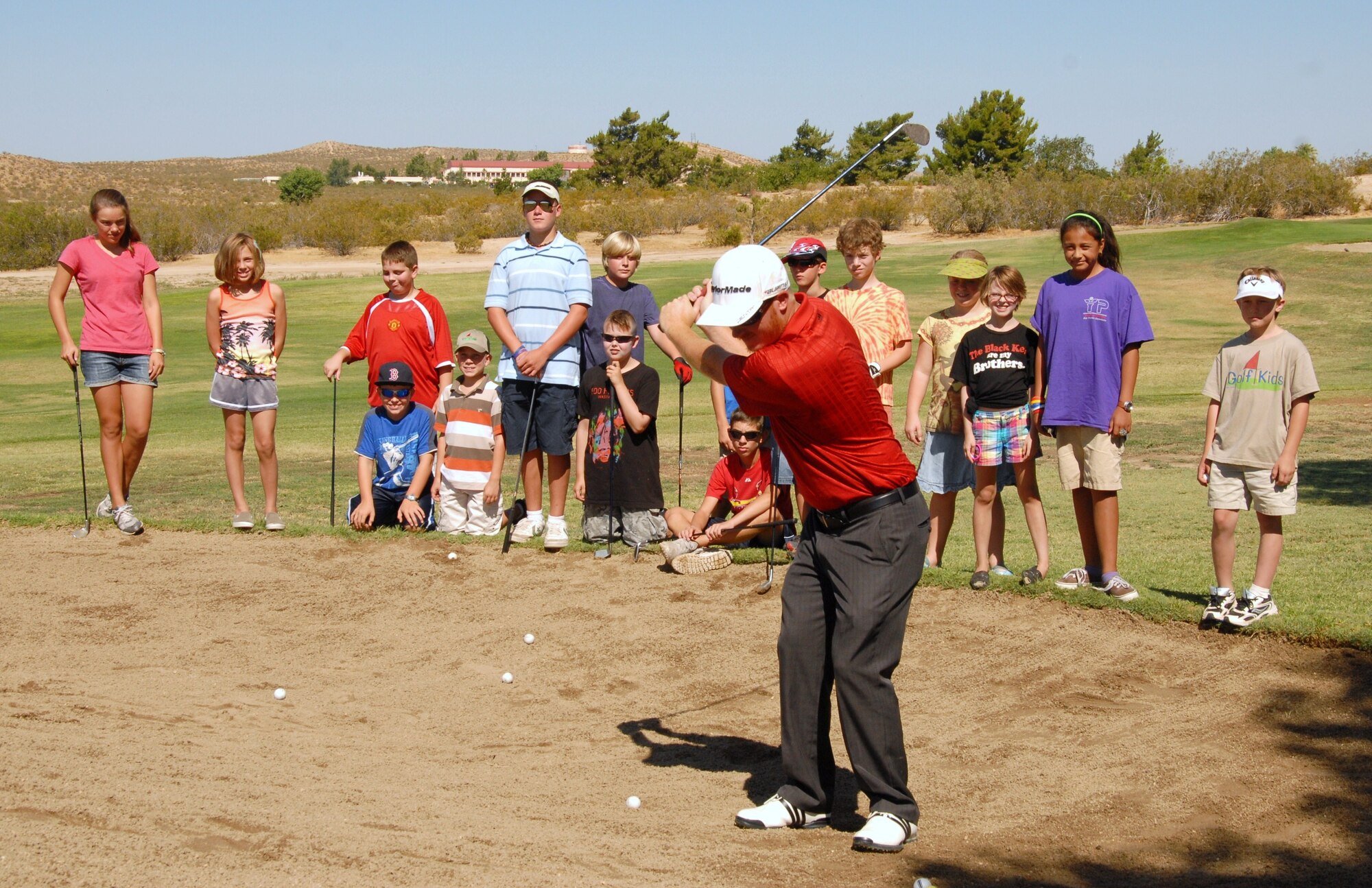 Muroc Lake Golf Course pro Ricky Lanning demonstrates a proper sand bunker golf swing to base children July 29. The week-long clinic provided a beginner’s course to the young aspiring golfers. Muroc Lake holds many events to improve golf skills and introduce the game to beginners. (Air Force photo by Kenji Thuloweit)