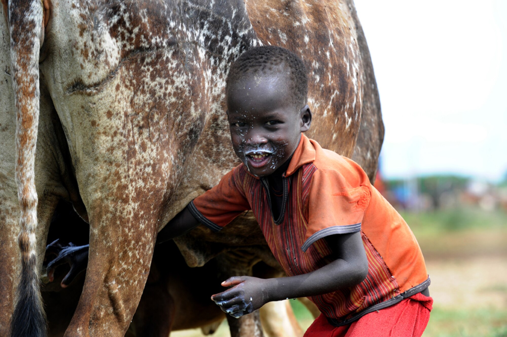 A child gets milk in the remote Karamoja region of Uganda. (U.S. Air Force Photo/Master Sgt Dawn Price) 