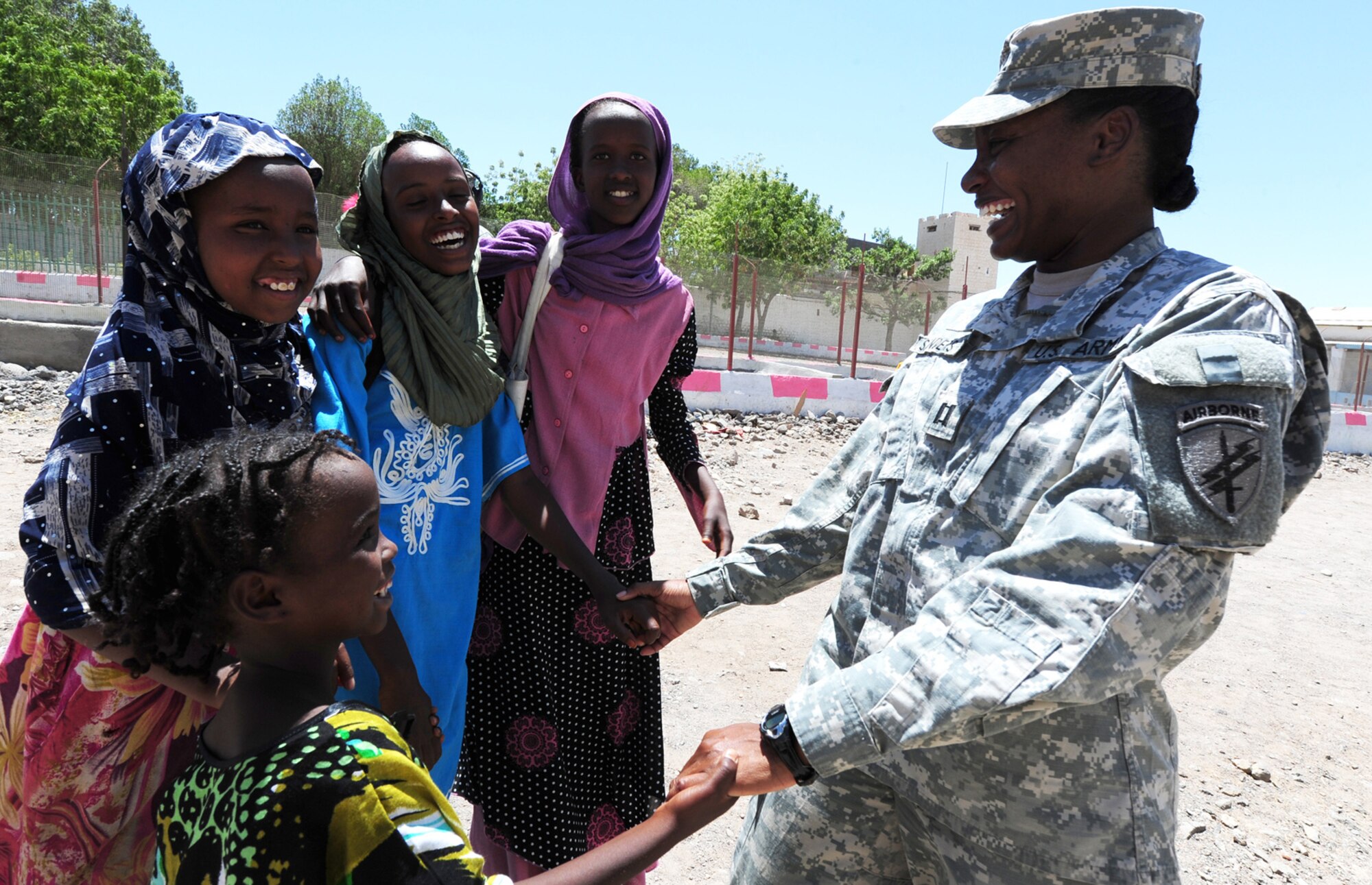 110419-F-XM360-102 Dikhil, Djibouti (March 19, 2011) - U.S. Army Capt. Courtney Sanders, 402nd Civil Affairs Battalion, spends a little time with a group of local girls April 19, after finishing up for the day at a school renovation project.   The 402nd civil affairs team, CJTF-HOA interacts with various villages and local key leaders in order to foster better understanding and communication, while building relationships that allow CJTF-HOA forces to partner with the host nation.  (U.S. Air Force photo/Master Sgt. Dawn Price)