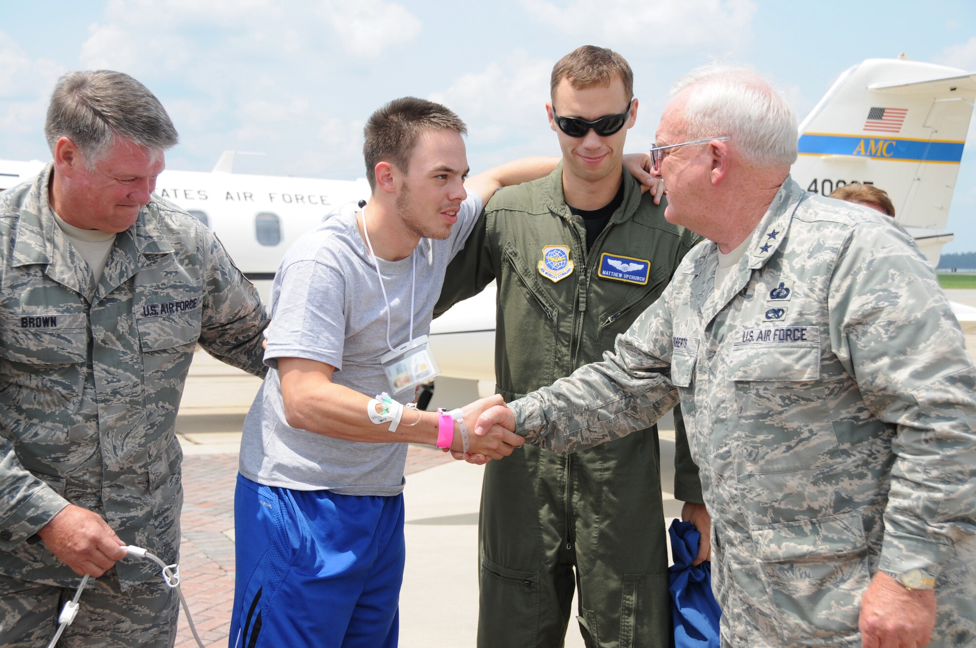 Senior Airman Jeremy Buckley, second from left, is welcomed to Keesler August 5 by Chief Master Sgt. James Brown, left; Capt. Matthew Upchurch and Maj. Gen. Alex “Don” Roberts. Buckley, deployed to Afghanistan from the 238th Air Support Operations Squadron, Key Field, Miss., received shrapnel to the right leg from an improvised explosive device July 29. He came to Keesler Hospital via Landstuhl Army Medical Center, Germany, and Andrews Air Force Base, Md. Brown is the 238th ASOS superintendent; Upchurch is the co-pilot from Scott AFB, Ill., who assisted in Buckley’s transport and Roberts is assistant adjutant general-air, Mississippi Air National Guard, Mississippi Joint Task Force, Jackson, and serves as Mississippi Air National Guard commander.  (U.S. Air Force photo by Kemberly Groue)
