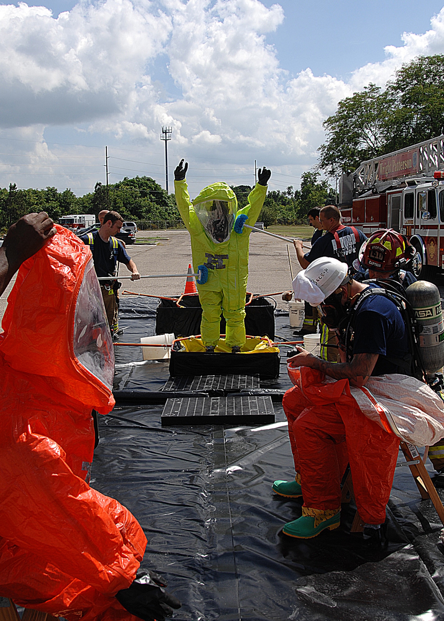Wright-Patterson Air Force Base firefighters perform technical decontamination on a first responder wearing a Level-A hazardous materials suit during a base exercise Aug. 4, 2011.  The scenario, one of several played out during the week, included suspected release of a toxic substance following an explosion at the Jarvis Gymnasium.  First responders included base security forces, firefighters, explosive ordnance disposal, medical and bioenvironmental engineering specialized teams who performed tasks under the watchful eyes of exercise evaluators.  The next series of quarterly exercises are planned Oct. 31 through Nov. 4.  (U.S. Air Force photo/Ben Strasser)