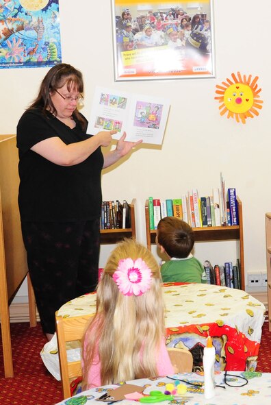 RAF MILDENHALL, England -- Suzanne Childress, a Red Cross volunteer, reads a story to children at the craft and story time event at the base library here Aug. 10, 2011. This event is held Wednesdays from 10:30 to 11:15 a.m. and is open to children of base ID cardholders. (U.S. Air Force photo/Karen Abeyasekere)