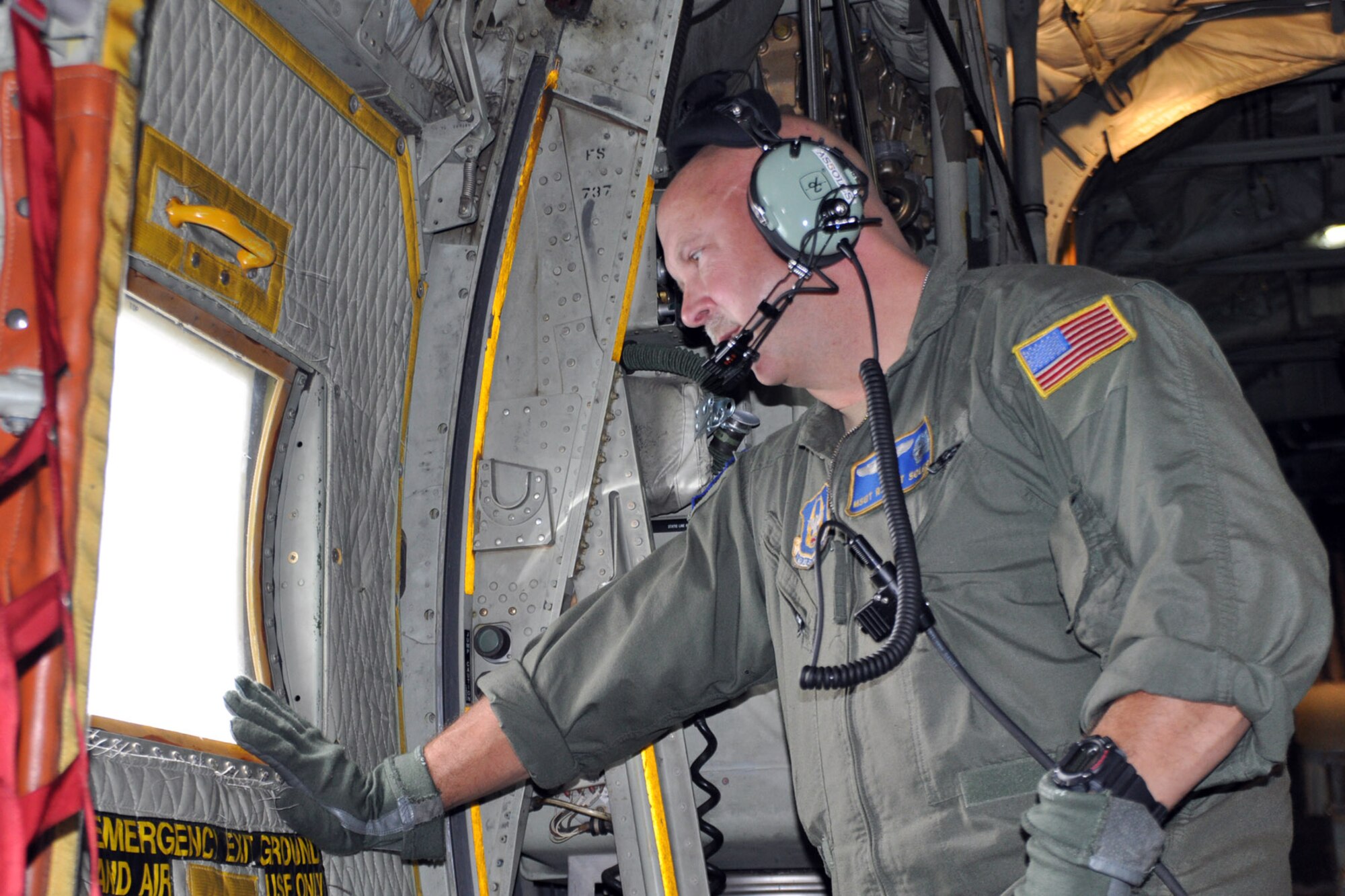 SOMEWHERE OVER NORTHEAST OHIO -- Air Force Reserve Master Sgt. Robert soles, a loadmaster assigned to the 757th Airlift Squadron, looks out the paratroop door window of a C-130H Hercules cargo transport, assigned to the 910th Airlift Wing, during a Spouse Flight, Aug. 6, 2011. The flight is part of Family Day activities held for the wing's Citizen Airmen and their families at Youngstown Air Reserve Station, Ohio. U.S. Air Force photo by Master Sgt. Bob Barko Jr.