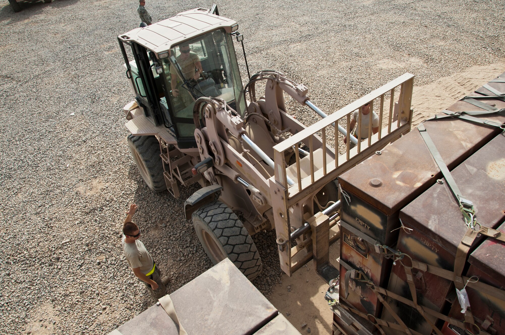 KANDAHAR AIRFIELD, Afghanistan -- Members of the 451st Expeditionary Maintenance Squadron Munitions Flight load a pallet of certified munitions containers onto a trailer Aug. 8, 2011. The pallets will then be turned in to the base's Defense Reutilization and Marketing Office for recycling. (U.S. Air Force photo by Senior Airman David Carbajal/Released)
