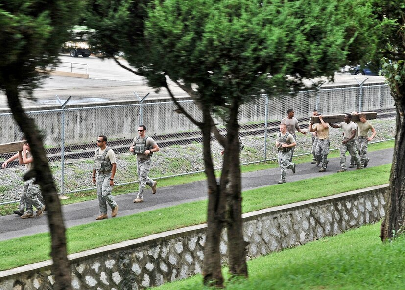 21 of the original 27 Airmen from the 51st Security Forces Squadron, who volunteered to try-out for the Quick Response Team, remain here, August 9. The Airmen were placed up against an elevated level of physical stress which tested not only their strength but also their capabilities to act as a cohesive squad. Throughout the day Airmen were also challenged to ensure the safety of on another while enduring the wear and tear of the physical portion of the tryouts. The Airmen were placed up against task such as completing a 5k as a squad while securing the 100 pound log over their shoulders, 4 sets of modified sit-ups, pushups and lunges which all were completed with the 100 pound log on the Airmen or being held by the Airmen with each set stopping at 31 in memory of the 31 warriors lost in Afghanistan, July 7. (U.S. Air Force Photos by/ Senior Airman Adam Grant)