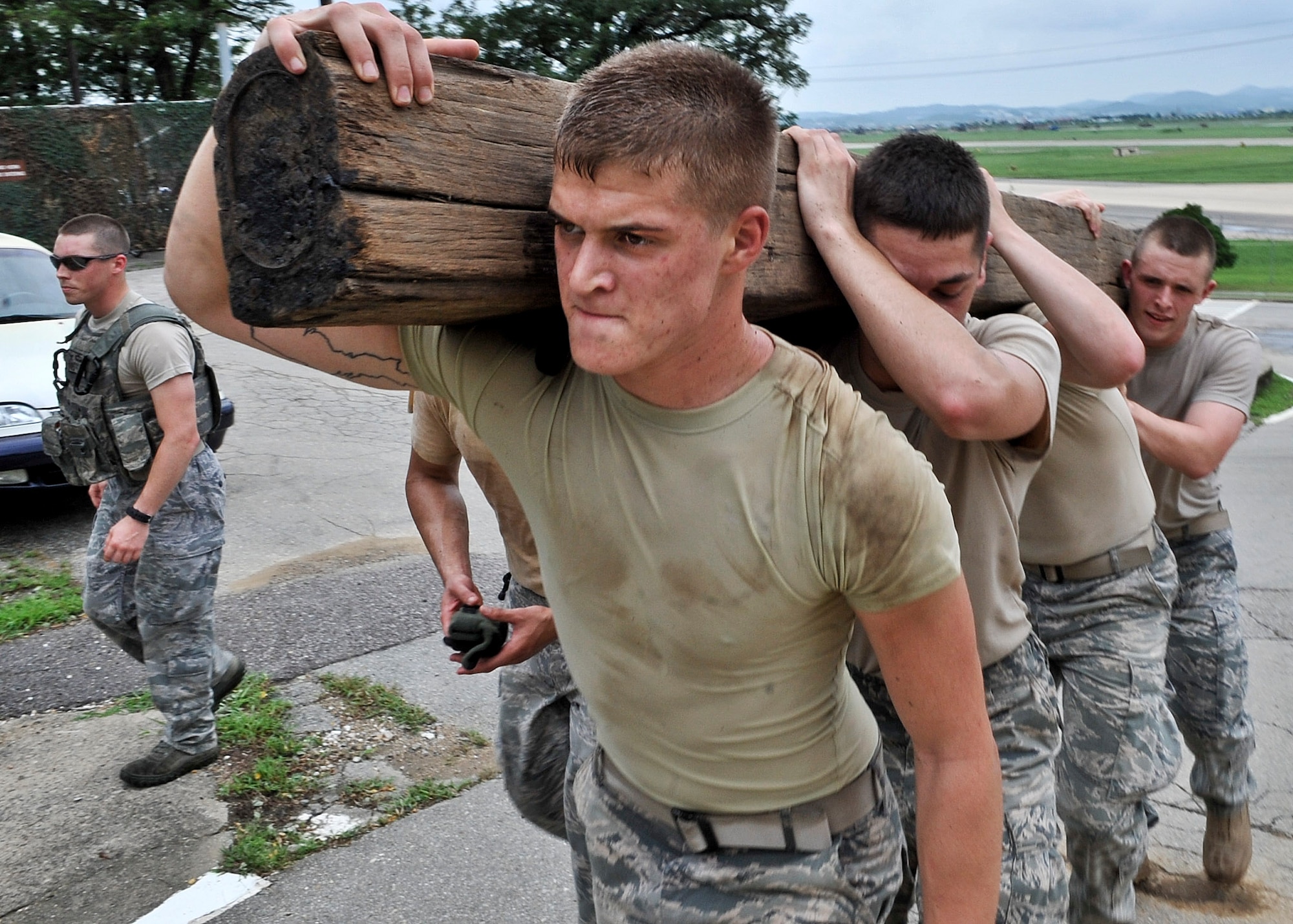 21 of the original 27 Airmen from the 51st Security Forces Squadron, who volunteered to try-out for the Quick Response Team, remain here, August 9. The Airmen were placed up against an elevated level of physical stress which tested not only their strength but also their capabilities to act as a cohesive squad. Throughout the day Airmen were also challenged to ensure the safety of on another while enduring the wear and tear of the physical portion of the tryouts. The Airmen were placed up against task such as completing a 5k as a squad while securing the 100 pound log over their shoulders, 4 sets of modified sit-ups, pushups and lunges which all were completed with the 100 pound log on the Airmen or being held by the Airmen with each set stopping at 31 in memory of the 31 warriors lost in Afghanistan, July 7. (U.S. Air Force Photos by/ Senior Airman Adam Grant)