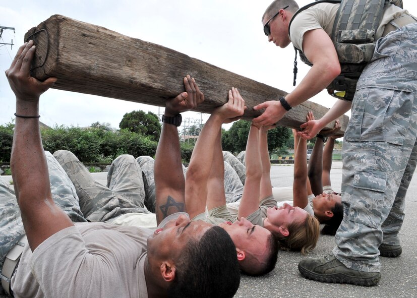 21 of the original 27 Airmen from the 51st Security Forces Squadron, who volunteered to try-out for the Quick Response Team, remain here, August 9. The Airmen were placed up against an elevated level of physical stress which tested not only their strength but also their capabilities to act as a cohesive squad. Throughout the day Airmen were also challenged to ensure the safety of on another while enduring the wear and tear of the physical portion of the tryouts. The Airmen were placed up against task such as completing a 5k as a squad while securing the 100 pound log over their shoulders, 4 sets of modified sit-ups, pushups and lunges which all were completed with the 100 pound log on the Airmen or being held by the Airmen with each set stopping at 31 in memory of the 31 warriors lost in Afghanistan, July 7. (U.S. Air Force Photos by/ Senior Airman Adam Grant)