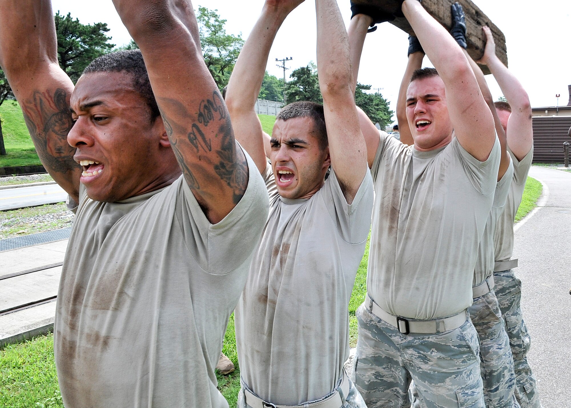 21 of the original 27 Airmen from the 51st Security Forces Squadron, who volunteered to try-out for the Quick Response Team, remain here, August 9. The Airmen were placed up against an elevated level of physical stress which tested not only their strength but also their capabilities to act as a cohesive squad. Throughout the day Airmen were also challenged to ensure the safety of on another while enduring the wear and tear of the physical portion of the tryouts. The Airmen were placed up against task such as completing a 5k as a squad while securing the 100 pound log over their shoulders, 4 sets of modified sit-ups, pushups and lunges which all were completed with the 100 pound log on the Airmen or being held by the Airmen with each set stopping at 31 in memory of the 31 warriors lost in Afghanistan, July 7. (U.S. Air Force Photos by/ Senior Airman Adam Grant)