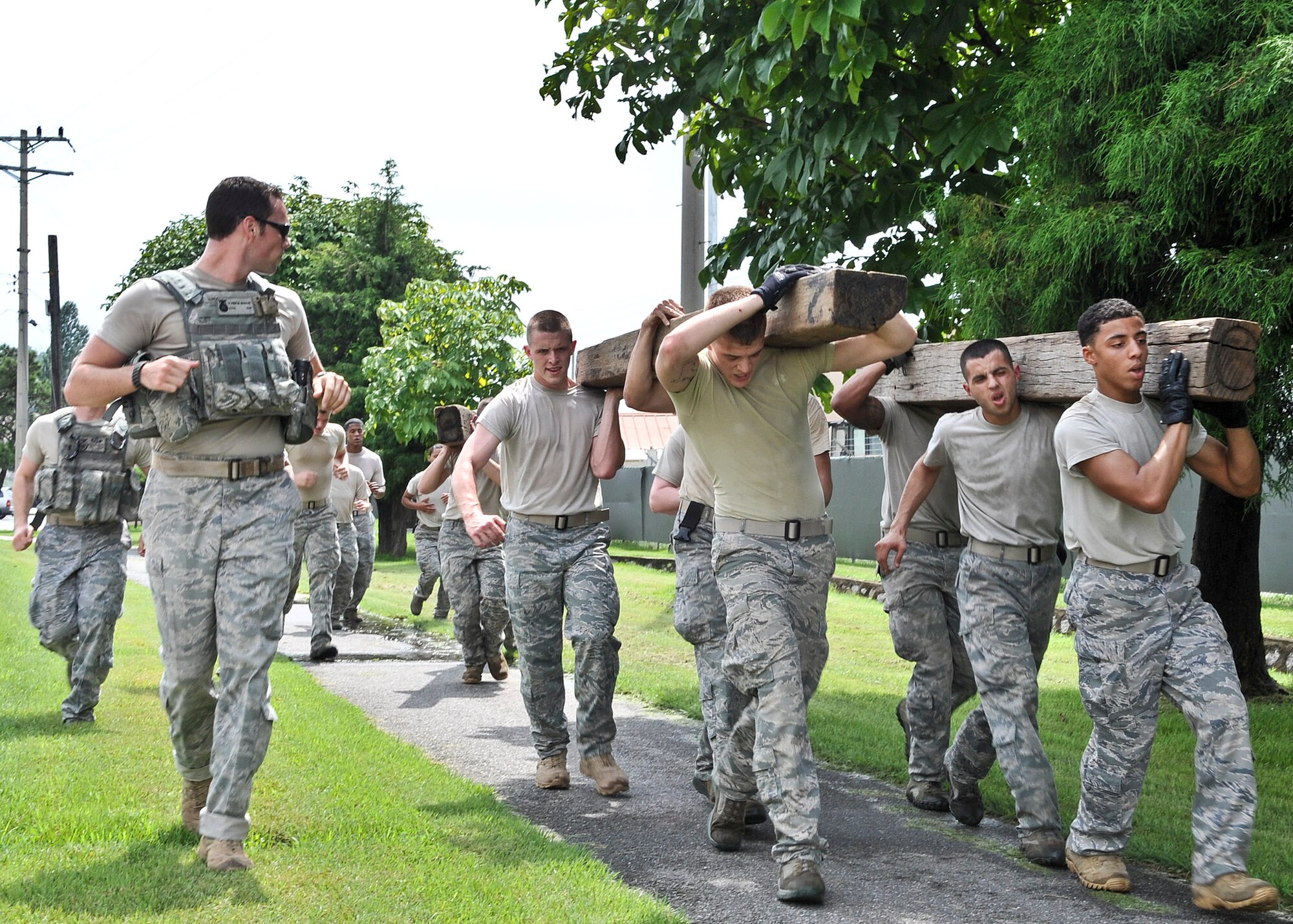21 of the original 27 Airmen from the 51st Security Forces Squadron, who volunteered to try-out for the Quick Response Team, remain here, August 9. The Airmen were placed up against an elevated level of physical stress which tested not only their strength but also their capabilities to act as a cohesive squad. Throughout the day Airmen were also challenged to ensure the safety of on another while enduring the wear and tear of the physical portion of the tryouts. The Airmen were placed up against task such as completing a 5k as a squad while securing the 100 pound log over their shoulders, 4 sets of modified sit-ups, pushups and lunges which all were completed with the 100 pound log on the Airmen or being held by the Airmen with each set stopping at 31 in memory of the 31 warriors lost in Afghanistan, July 7. (U.S. Air Force Photos by/ Senior Airman Adam Grant)
