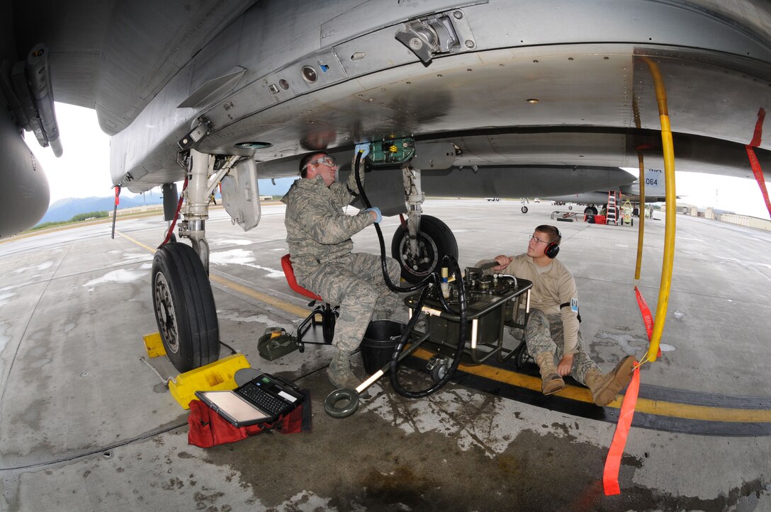 Tech. Sgt. Aaron Richards and Senior Airmen Kyle Bienia service a part on an F-15 Eagle while deployed to Joint Base Elmendorf-Richardson, Alaska in support of a training exercise. (U.S. Air Force photo/Tech. Sgt. Anthony Mutti)