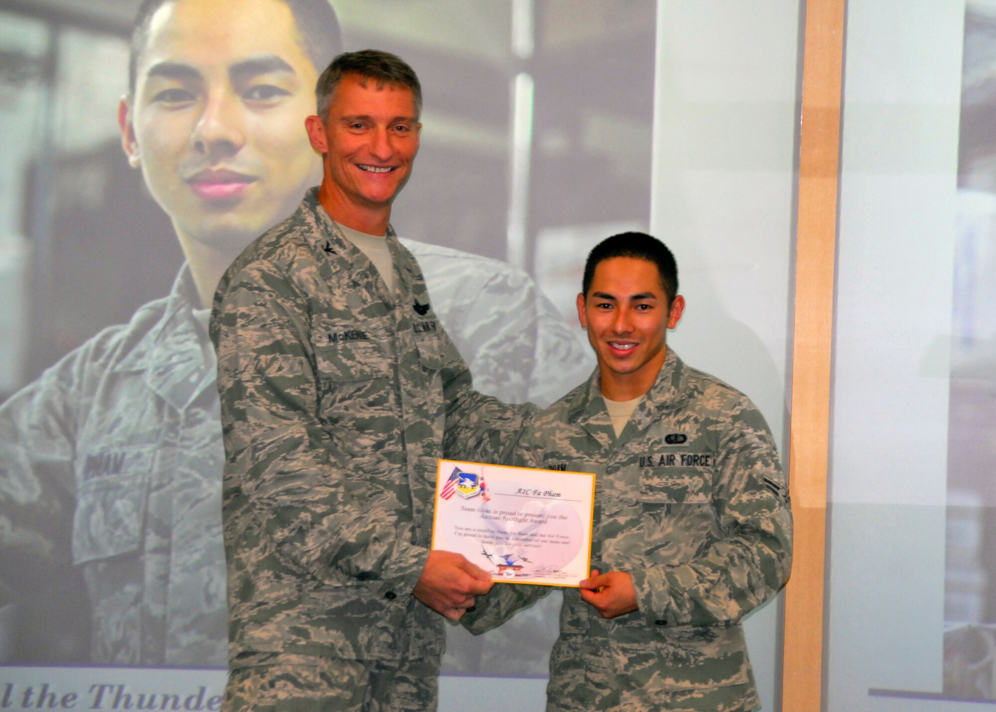 Col. Patrick McKenzie, 51st Fighter Wing commander, awards Airman 1st Class Fa Pham, 51st Force Support Squadron, with a certificate recognizing him as the Airman Spotlight of the week August 9, 2011. (U.S. Air Force photo/Senior Master Sgt. Stuart Camp)