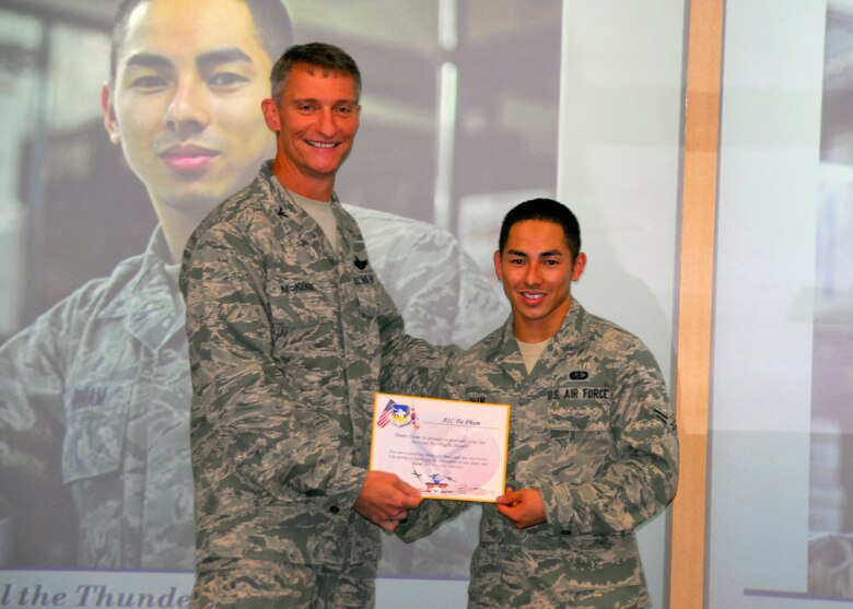 Col. Patrick McKenzie, 51st Fighter Wing commander, awards Airman 1st Class Fa Pham, 51st Force Support Squadron, with a certificate recognizing him as the Airman Spotlight of the week August 9, 2011. (U.S. Air Force photo/Senior Master Sgt. Stuart Camp)