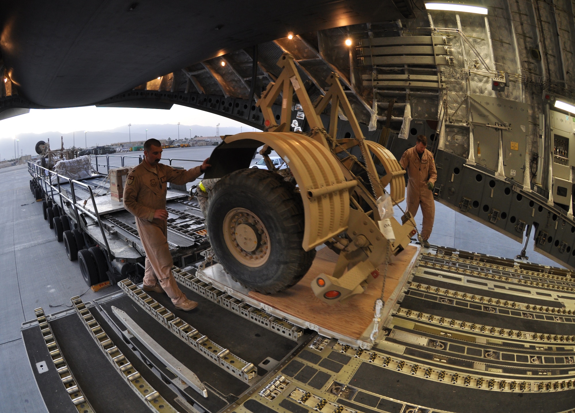 BAGRAM AIRFIELD, Afghanistan -- BAGRAM AIRFIELD, Afghanistan -- Airmen from the 455th Expeditionary Aerial Port Squadron work side by side with loadmasters to load a C-17 Globemaster III with cargo here August 1, 2011. The 455 EAPS’s mission is moving passengers and cargo all throughout Afghanistan. More than 80 percent of all people and supplies traveling through the country come through 455 EAPS. (U.S. Air Force photo/Staff Sgt. John Wright)
