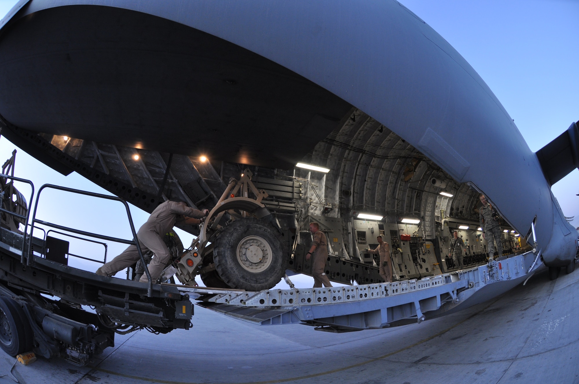 BAGRAM AIRFIELD, Afghanistan -- Airmen from the 455th Expeditionary Aerial Port Squadron work side by side with loadmasters to load a C-17 Globemaster III with cargo here August 1, 2011. The 455 EAPS’s mission is moving passengers and cargo all throughout Afghanistan. More than 80 percent of all people and supplies traveling through the country come through 455 EAPS. (U.S. Air Force photo/Capt. Korry Leverett)
