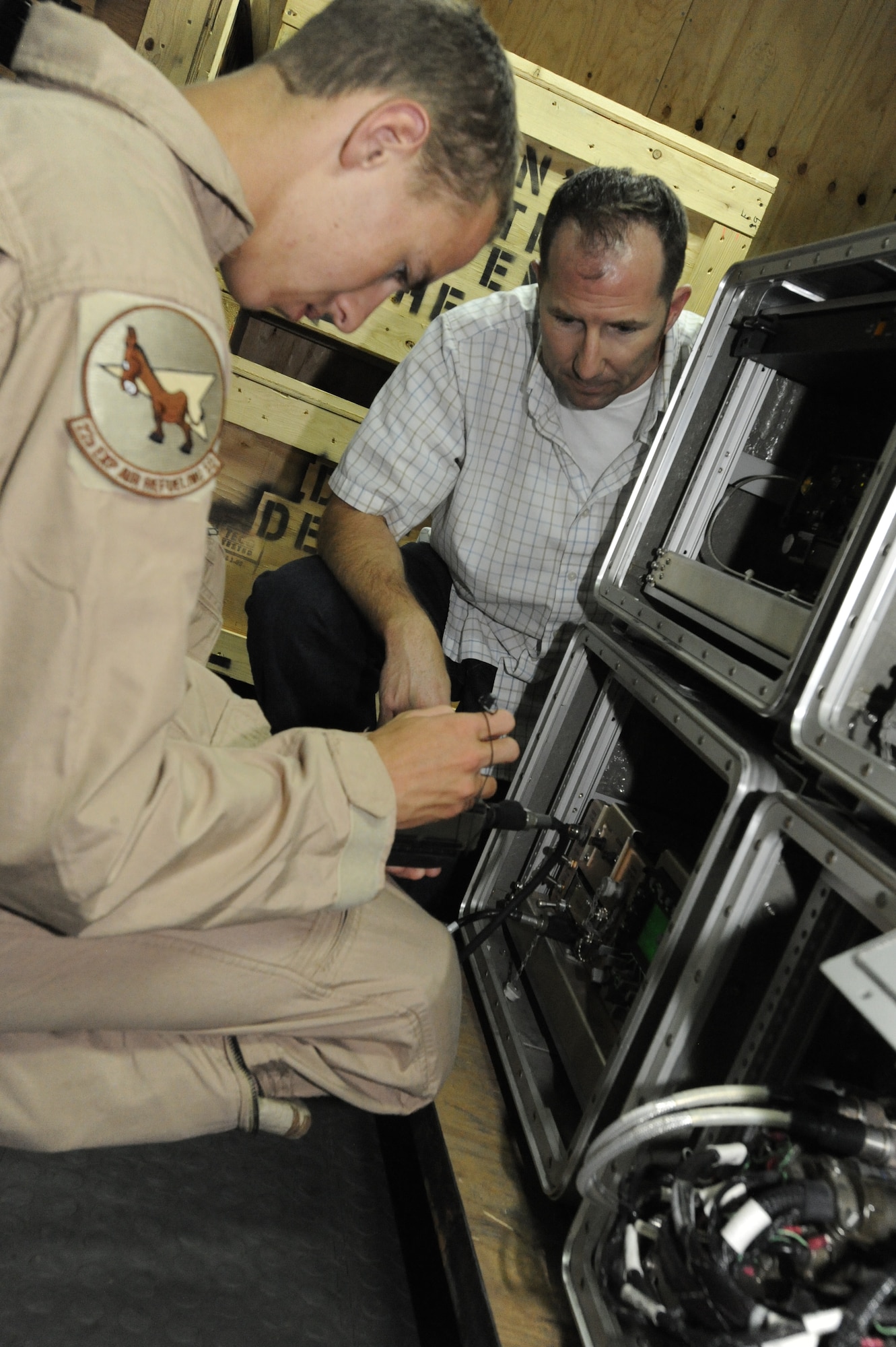 Airman 1st Class Cameron Bilyeu enters data into the roll-on, beyond-line-of-sight enhancement system during a training session instructed by Adam Simons at the Transit Center at Manas, Kyrgyzstan, Aug. 5. The ROBE system enhances the military's overall battlefield command and control communication ability. Bilyeu is deployed to the 22nd Expeditionary Air Refueling Squadron as a boom operator.  He is deployed here from Fairchild Air Force Base, Wash. Simons is a Northrop Grumman ROBE system field engineer. (U.S. Air Force photo/Tech. Sgt. Tammie Moore)